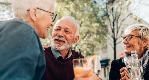 Aspire Blog - Holidays and hearing loss - three adults conversing outside having drinks