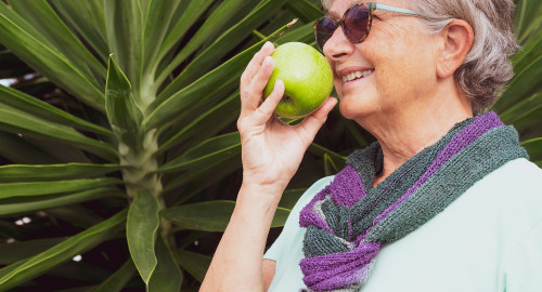 Aspire Blog - Creating a Wellness Vision - Woman eating healthy holding an apple