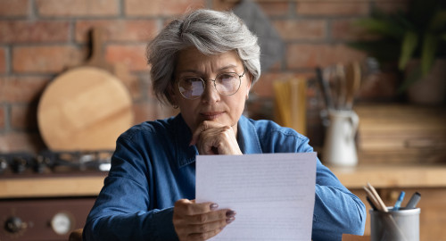 Aspire Blog - Questions about Medicare - Woman with glasses starting at a paper thinking