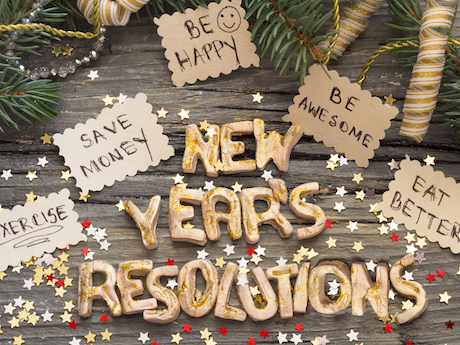 New Year's resolutions such as save money and be happy written on cards