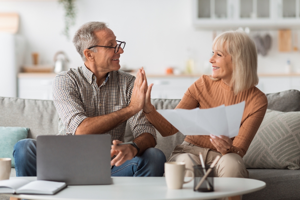 Happy couple high-fiving after learning how to save money with the Inflation Reduction Act