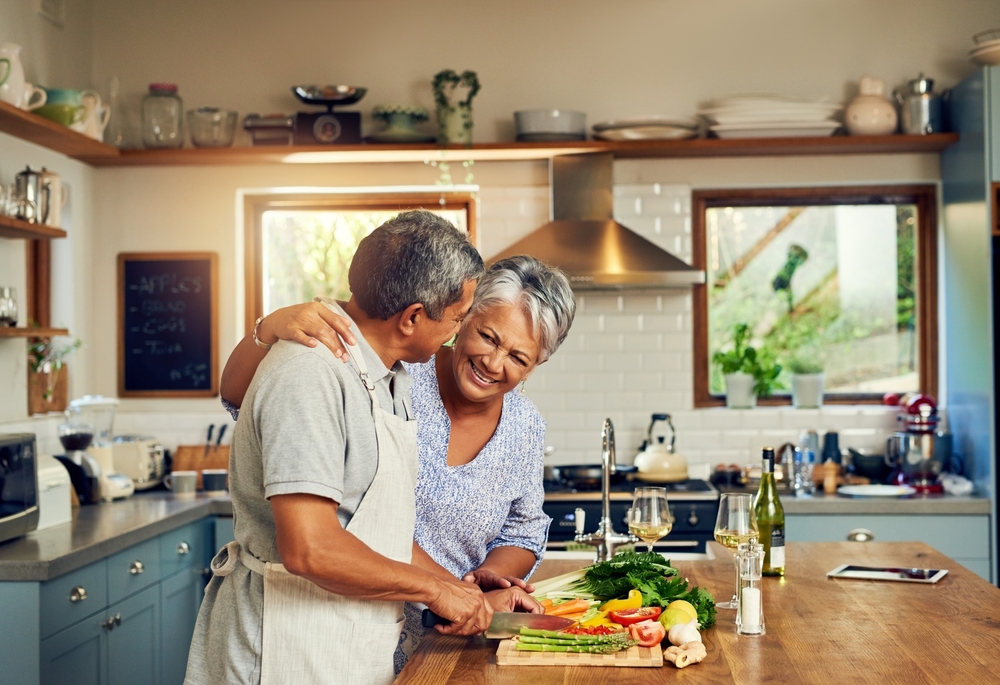 Happy older couple cooks a delicious, healthy meal following expert tips